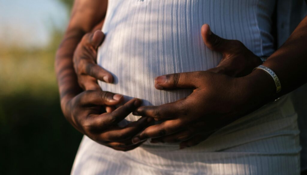 Casal com as mãos na barriga de uma gestante (Crédito: Kei Scampa/Pexels)