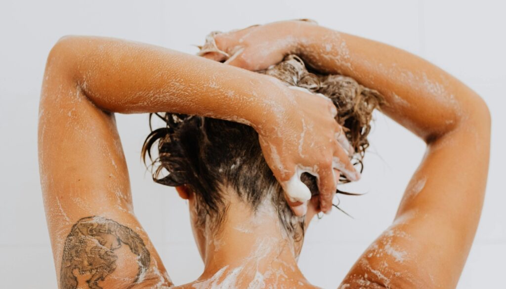Mulher lavando os cabelos no banho (Crédito: Karolina Kaboompics/Pexels)