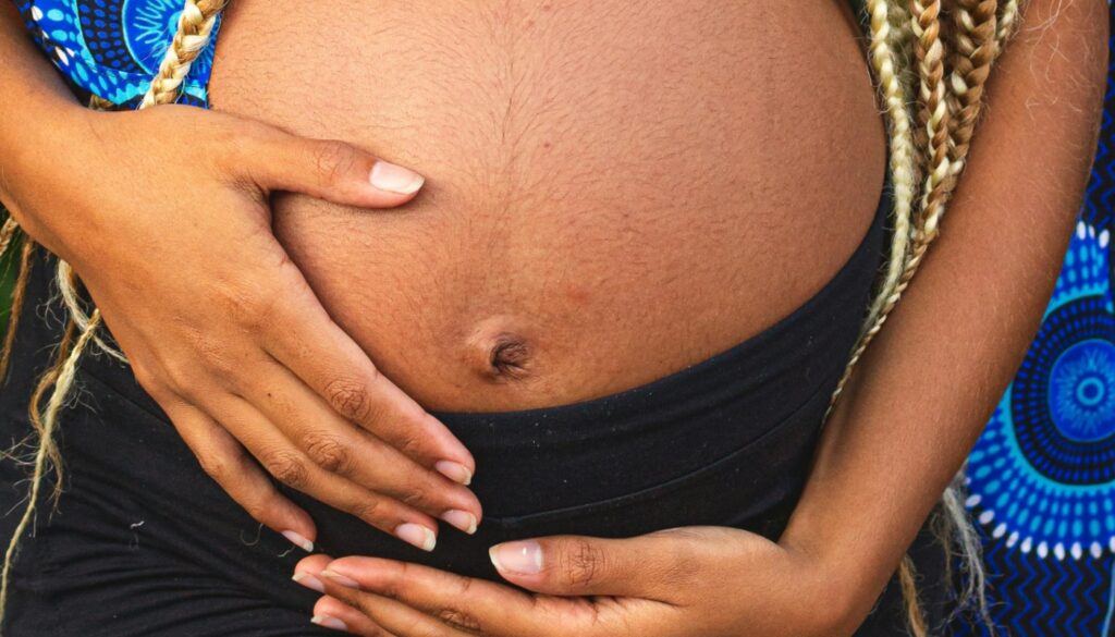 Gestante com as mãos na barriga (Crédito: Italo Crespi/Pexels)