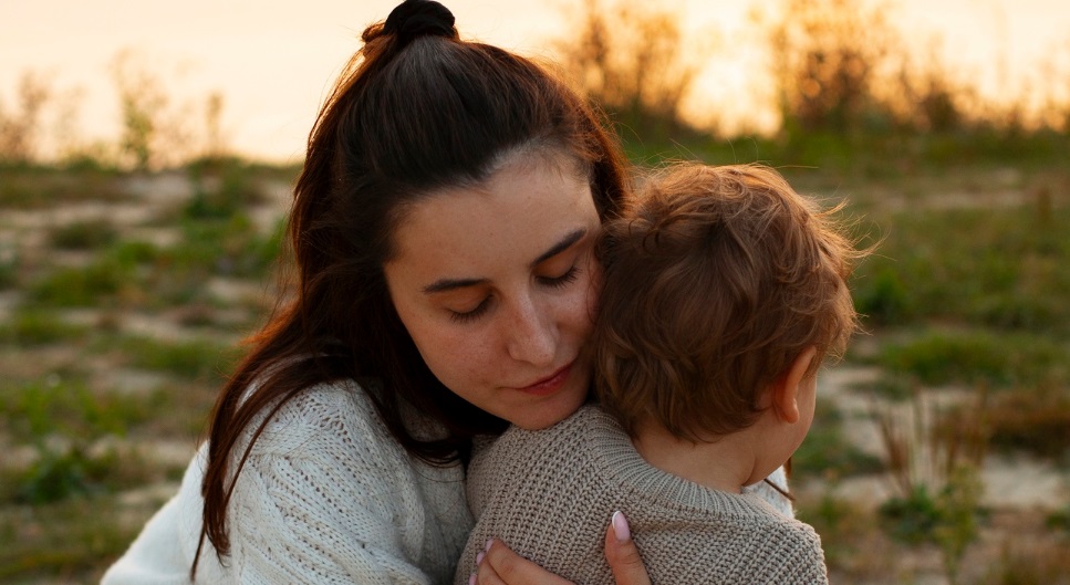 Mãe acolhendo criança (Crédito: Freepik)