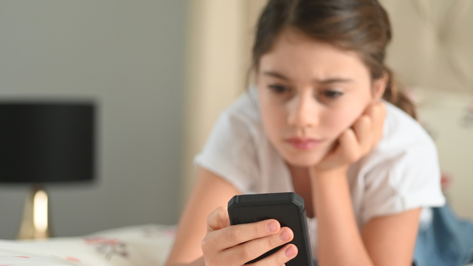 Menina olhando celular com tensão