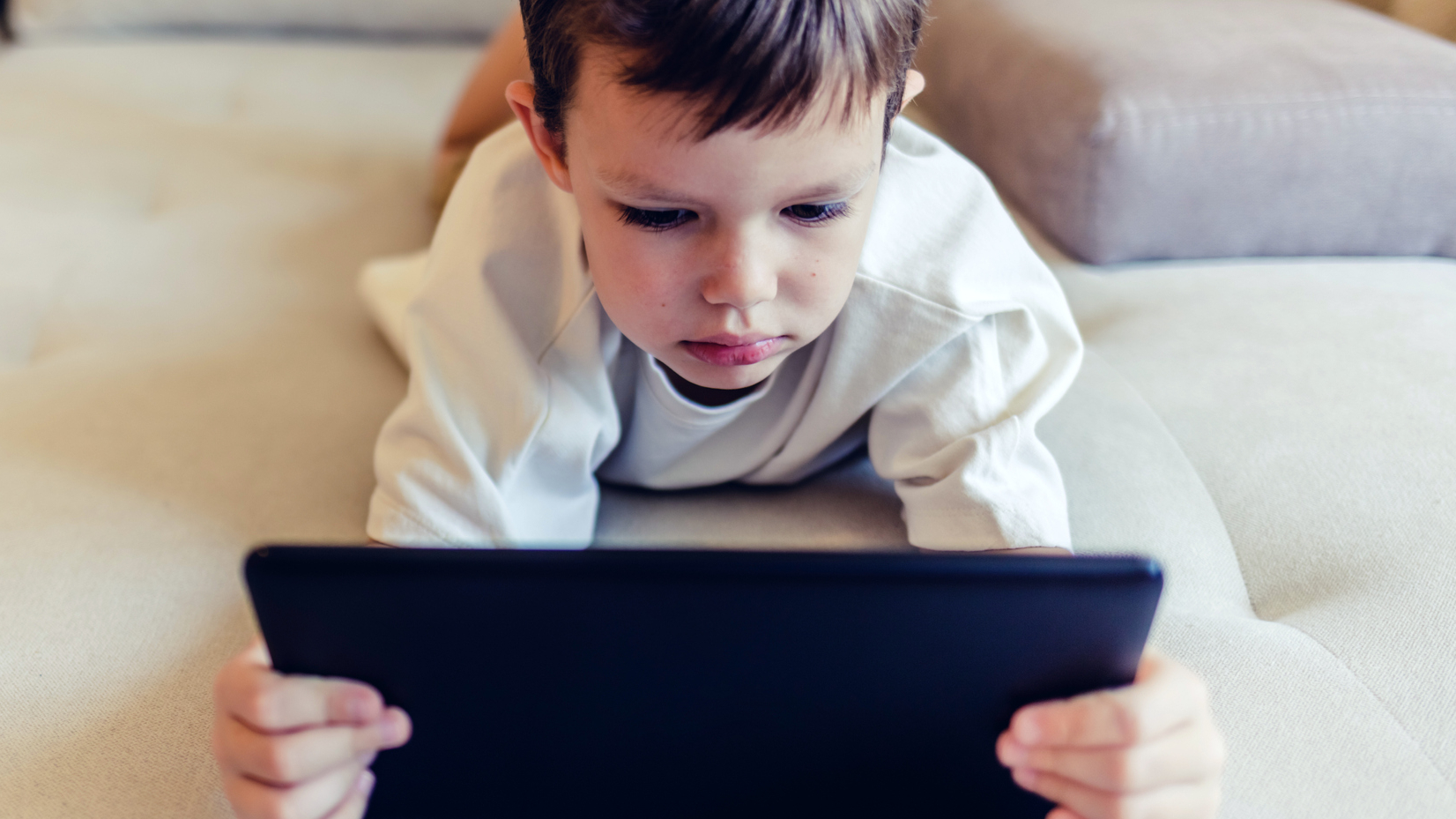 Garotinho usando um tablet para se distrair