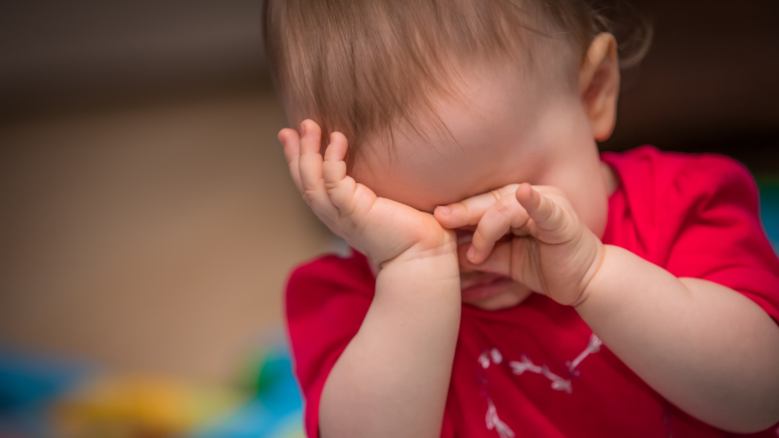 Bebê coçando os olhos.